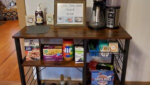 A coffee bar with a sign reading "Coffee, Tea, and Snack BAR" and a framed inspirational quote on the wall above. - Make this house your HOME away from home (Meade)