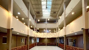Un espacio interior amplio con techo alto, varios niveles y un área central abierta.