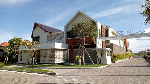 Un moderno edificio de dos pisos con techo plano, entrada visible y un letrero que dice 'The Ayudya'.