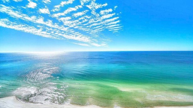 A beach with clear turquoise waters and a sandy shoreline. - “Walk to Beach • Park at Door • 11 Pools • Sleeps 6” (Panama City Beach)