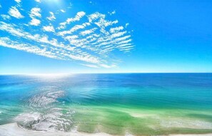 Een strand met helder turquoise water en een zandstrand.