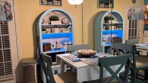A dining area with a nautical theme, featuring a table with a bowl of starfish, chairs, and a wall with a sea-themed mural and a sign that says "COME WITH ME TO THE SEA". - “Walk to Beach • Park at Door • 11 Pools • Sleeps 6” (Panama City Beach)