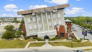 A building with a unique architectural design, featuring a slanted facade and multiple windows. - “Walk to Beach • Park at Door • 11 Pools • Sleeps 6” (Panama City Beach)