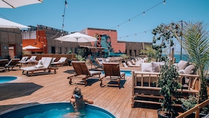 A rooftop pool area with lounge chairs, umbrellas, and potted plants. - SEVEN Tel Aviv (Tel Aviv)