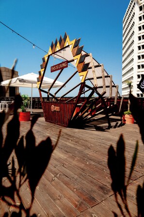 A wooden structure with a sign that reads 'THIS IS LIVING' and a Corona beer logo. - SEVEN Tel Aviv (Tel Aviv)