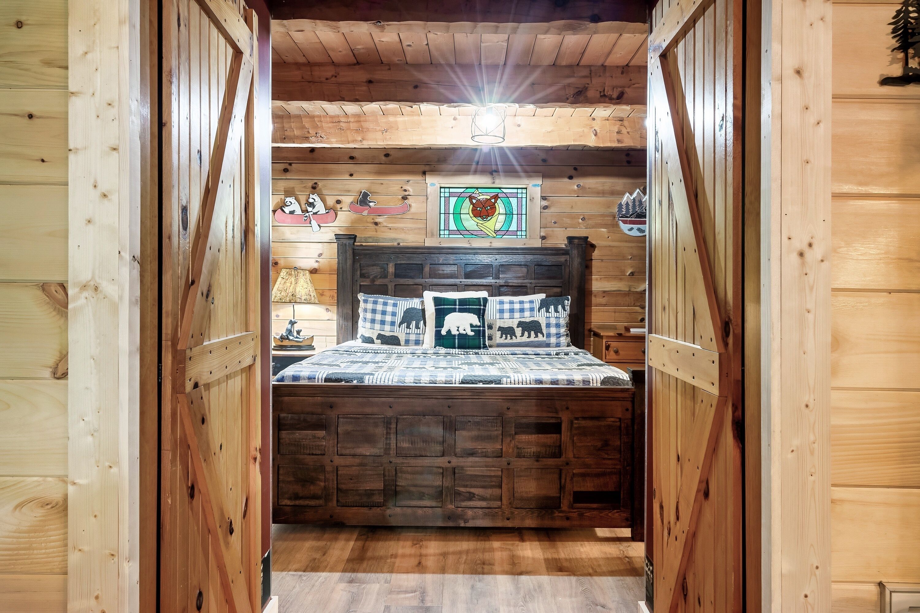 Ein Holzblock-Innenraum mit einem Bett, Holzwänden und einer Deckenleuchte.