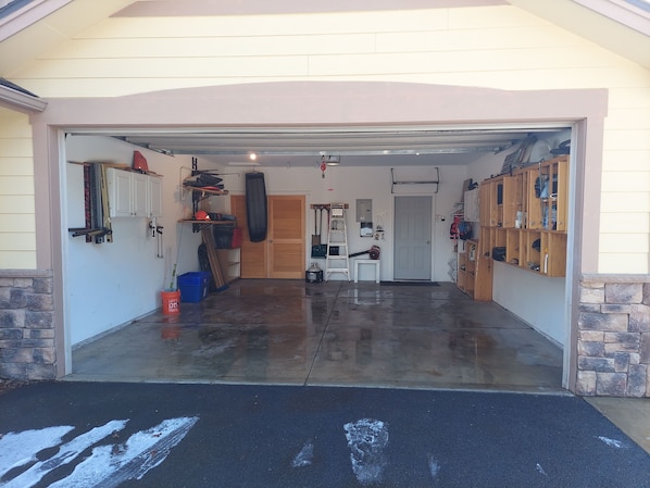 Equipped with a workbench, storage cabinets, and a punching bag, this garage offers ample space for projects and activities.