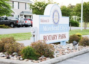 A sign for Morehead City's Rotary Park with a welcoming message and a logo. - Entire residential home rental. Quiet cul-de-sac. Minutes to beach. (Morehead City)
