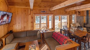 Un interior acogedor de cabaña con detalles de madera, un comedor y una chimenea.
