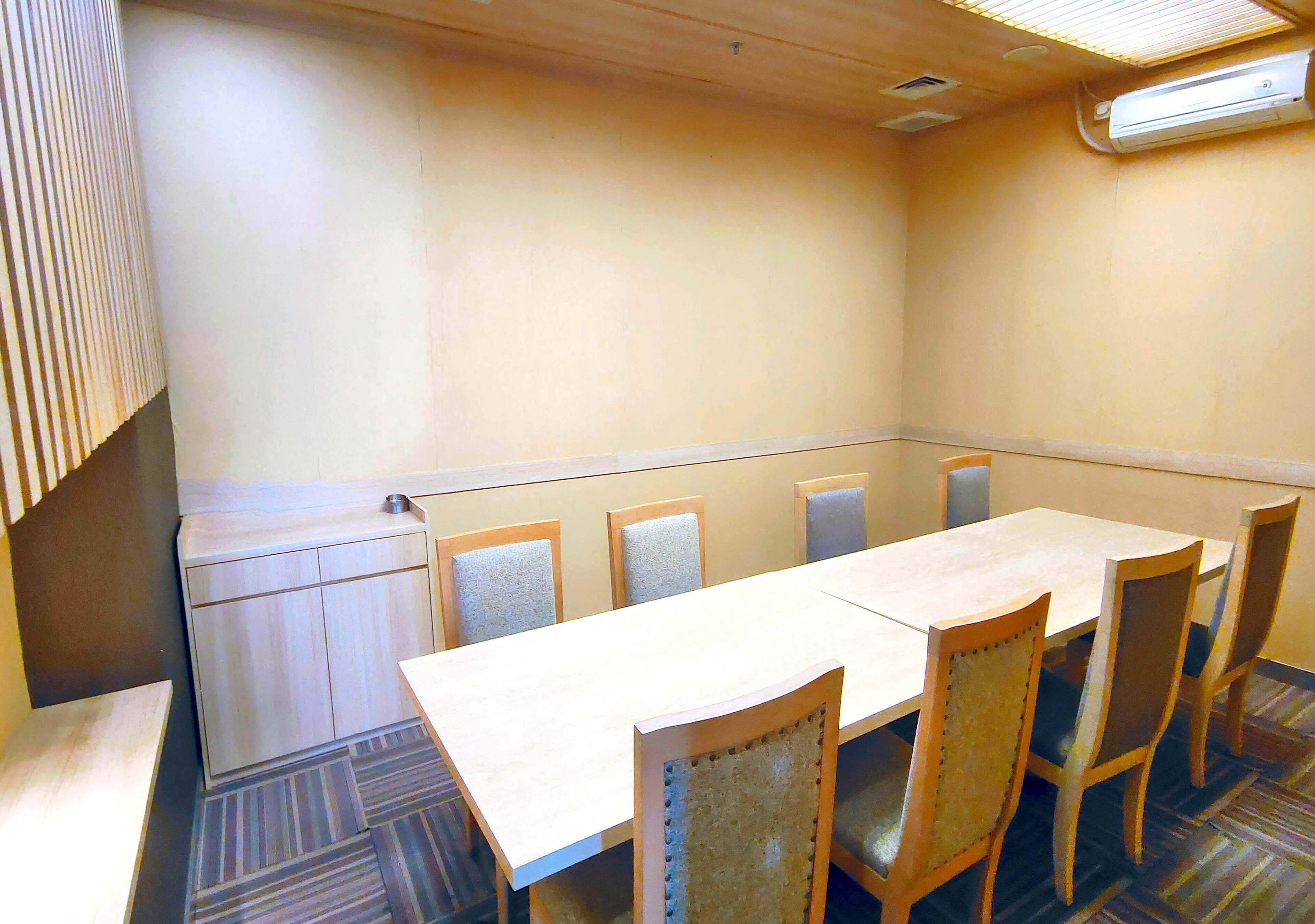 A conference room with a long table and six chairs.
