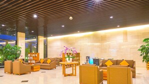 A spacious lobby with multiple sofas, a coffee table, and a bookshelf.