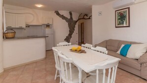 A compact living space with a dining area, kitchenette, and a sofa. - Rubinia by Interhome (Valledoria)