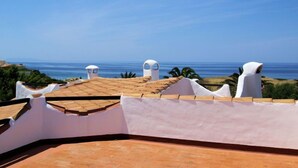 A rooftop terrace with a view of the sea, white walls, and a tiled roof. - Vacation home Tipo D by Interhome (Valledoria)