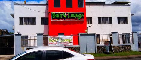 Un edificio con fachada roja y blanca, que muestra un letrero para el restaurante y bar 'Bula Lounge'.