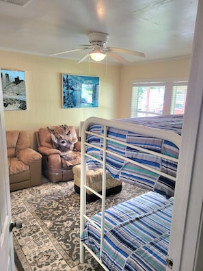 A bedroom with a bunk bed, a recliner, a massage chair, and a ceiling fan. - Game Day Getaway: Beautiful 5BR&8 Beds & 16 min to NRG, 12 min to Sabercats (Houston)