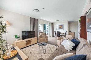 A modern living room with a TV, sofa, and coffee table.