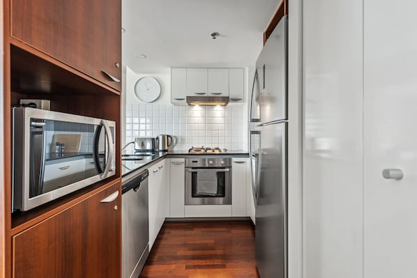 Enjoy cooking in this well-lit kitchen with a stainless steel range, oven, microwave, and coffee maker.