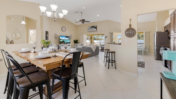 A spacious kitchen with a dining area, modern appliances, and a cozy seating area. - Gorgeous heated pool home - Villa Palm Tree - Roelens Vacations (Cape Coral)