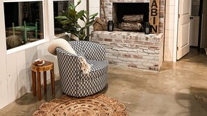 Una sala de estar acogedora con chimenea, un sofá estampado y un tapiz tejido.