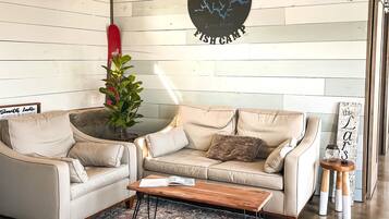 Un salon moderne avec un canapé, une table basse et un mur décoratif orné d’un panneau circulaire.