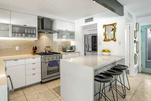 Enjoy cooking in this well-equipped kitchen with a large island, stove, oven, and microwave.