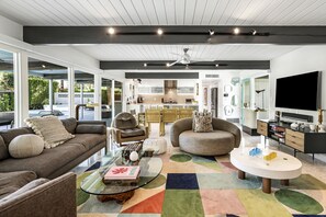 Relax in this stylish living area with a comfortable sofa, dining table, and mounted TV.
