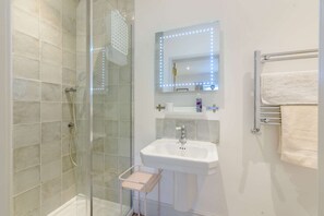 Een bad/douchecombinatie, een haardroger