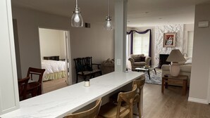A modern living room with a marble dining table, wooden chairs, a sofa, and a coffee table. - Beautiful Remodeled West Los Angeles condo - Brentwood adjacent.  (Los Angeles)