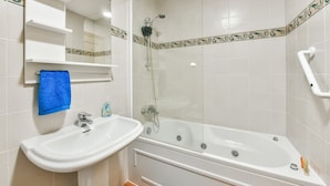 Un baño con lavamanos, espejo y ducha.