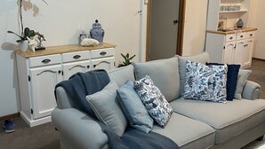 Ein Wohnzimmer mit einer Couch, einem Couchtisch, einem Schrank und einer Tür.