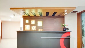 A reception desk with a modern design, featuring a black and red color scheme. - Aishwaryam Hotel (Madurai)