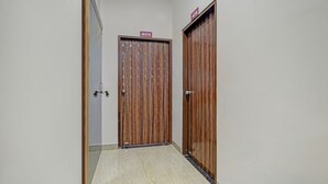 A hallway with two wooden doors, each marked with a number sign. - Treebo Alankar Hoshangabad Road (Bhopal)