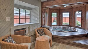 A spa area with a hot tub, wicker chairs, and large windows offering views of the backyard. - Game Room & Private Pool: Richardson Retreat (Richardson)