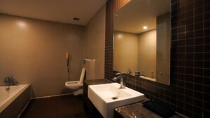Et moderne badeværelse med badekar, toilet og håndvask.