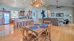 A spacious living area with a wooden dining table, chairs, and a chandelier. - Waterfront Home w/ Private Dock in Crystal River (Crystal River)