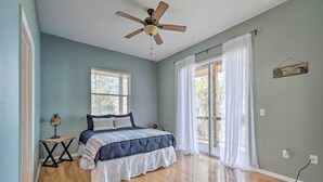 A bedroom with a bed, a ceiling fan, a window with blinds, and a view of the outdoors. - Waterfront Home w/ Private Dock in Crystal River (Crystal River)
