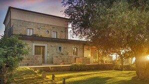 A stone building with a flat roof, a central entrance, and a small balcony. - Belvilla by OYO Hotel Alimunera (Naso)