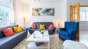 Un saló amb un sofà blau, una taula de cafè blanca i un armari blau.