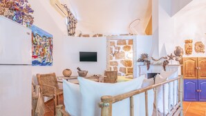 Eine Küche mit Steinwand, Fernseher, rustikalen Möbeln und Dekorationselementen.