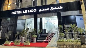 A multi-story hotel with balconies and a red carpet entrance. - Le Lido (Algiers)