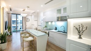 Een moderne keuken met witte kasten, een glazen eiland en een spoelbak.