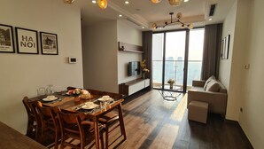 Een moderne woonkamer met een eethoek, een bank en een balkon met uitzicht op de stad.