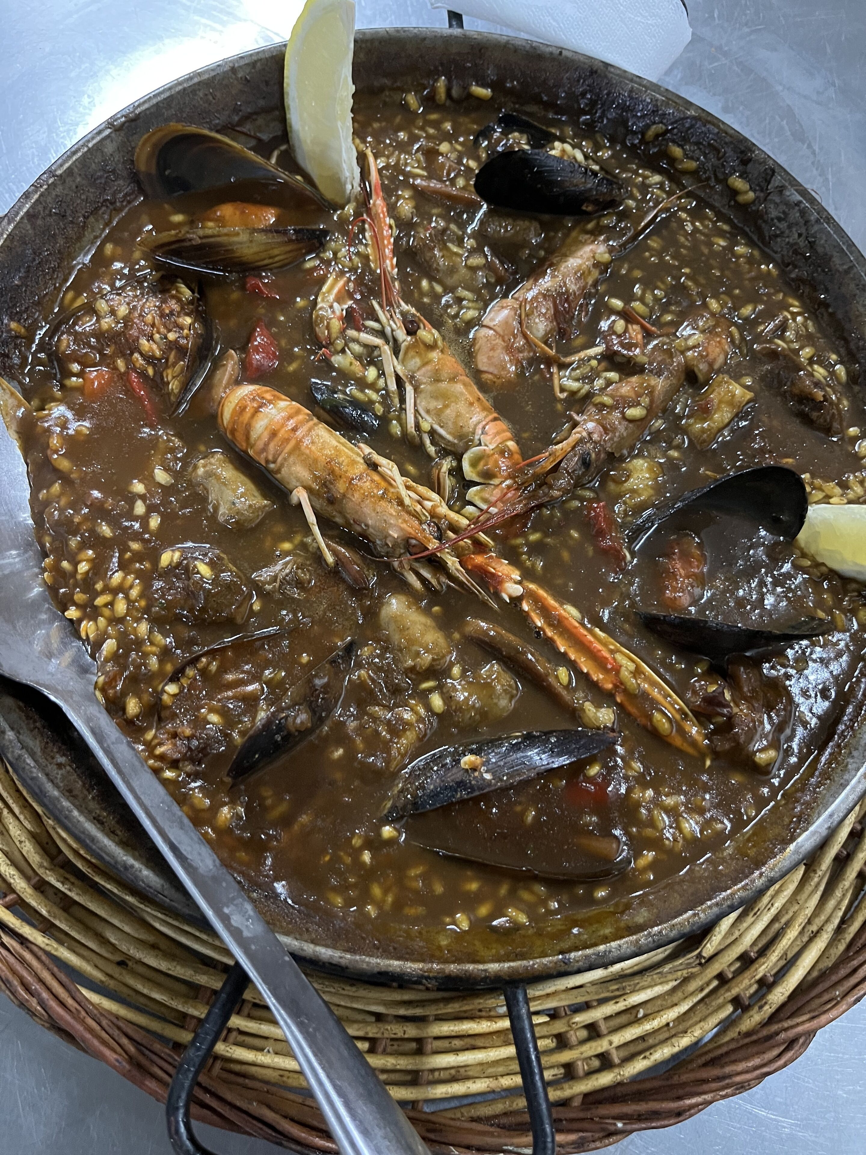 Un guiso de mariscos con diversos mariscos y verduras en una olla grande.