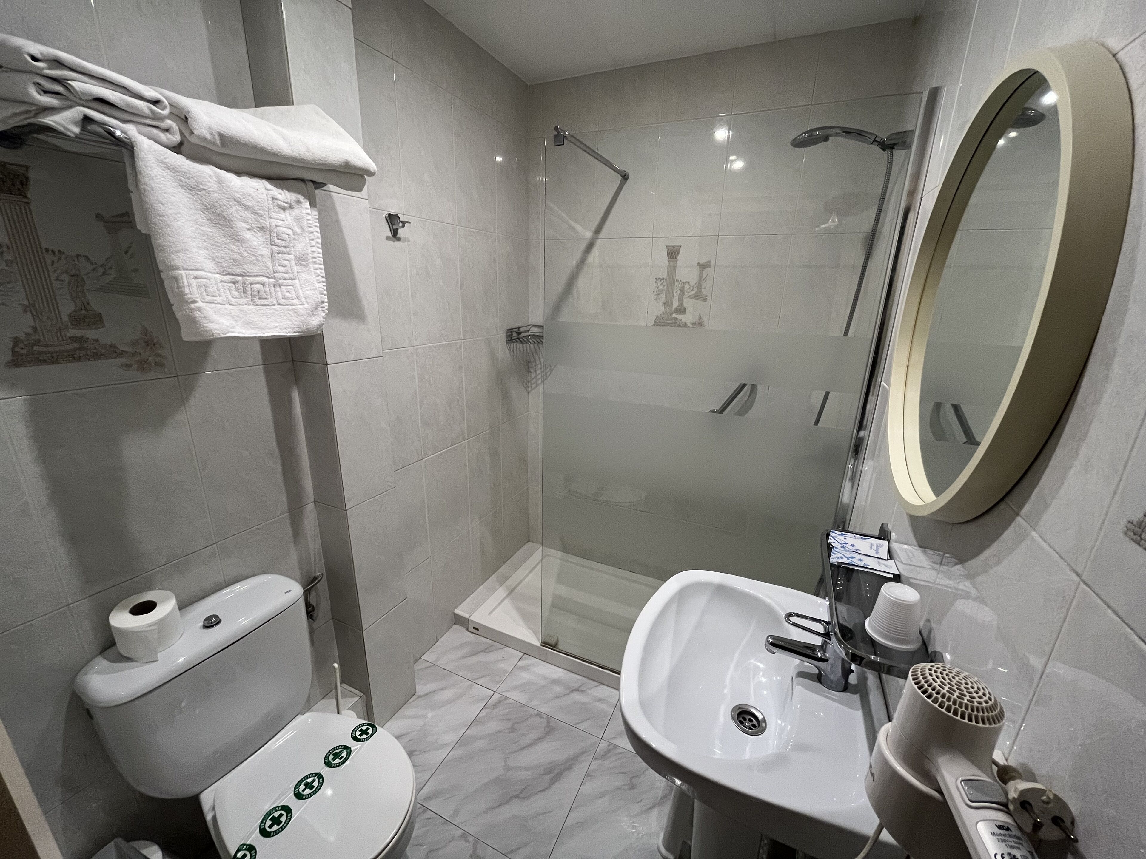 Une salle de bain moderne équipée de toilettes, d’un lavabo et d’une douche.