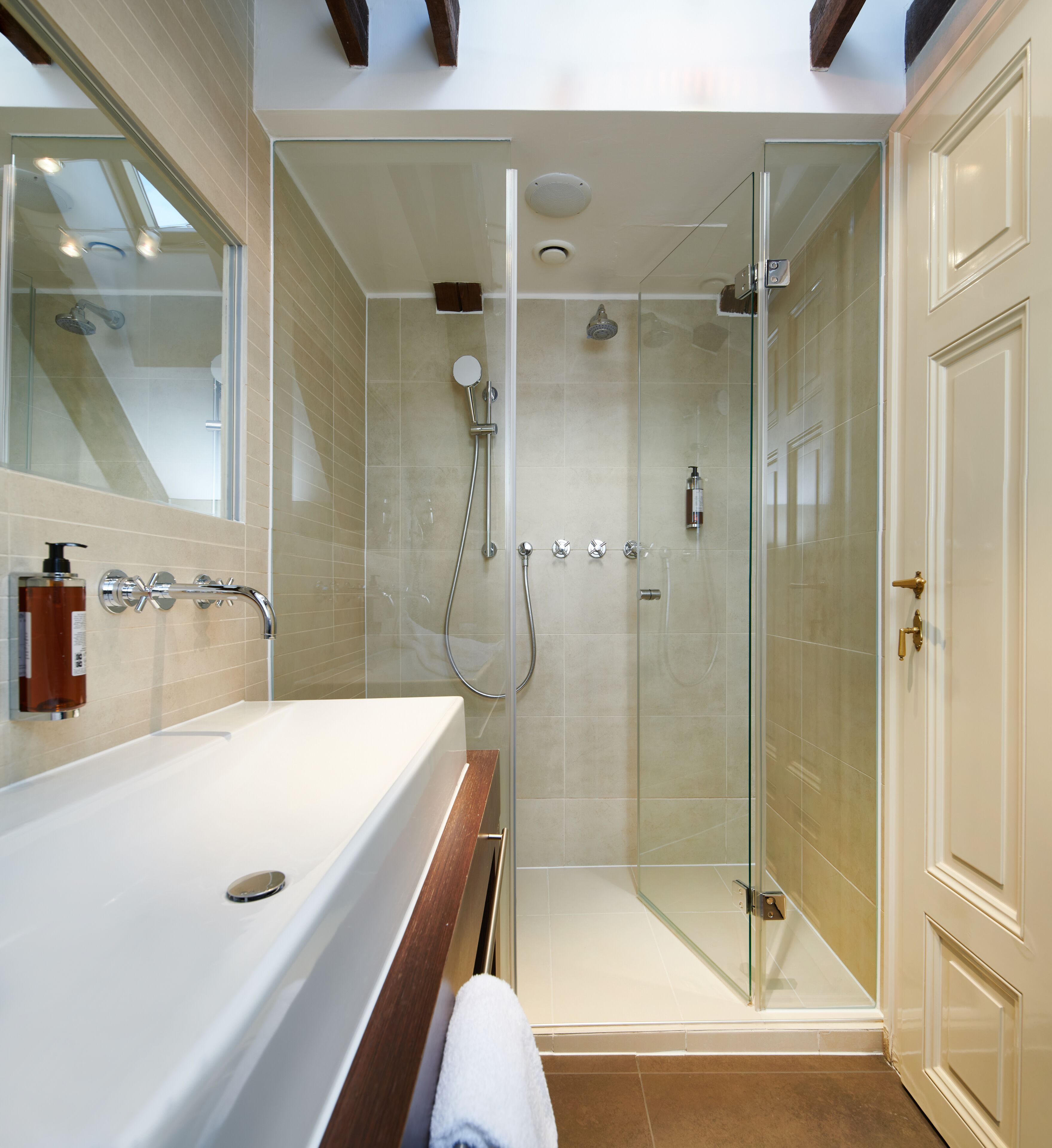 Un baño moderno con ducha de vidrio, una bañera grande y un tocador con espejo.