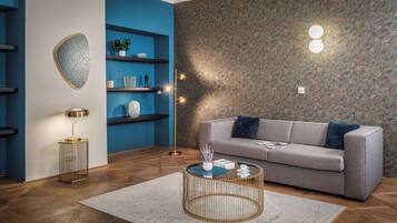 Un soggiorno moderno con un divano grigio, un tavolino rotondo e una parete blu con mensole.