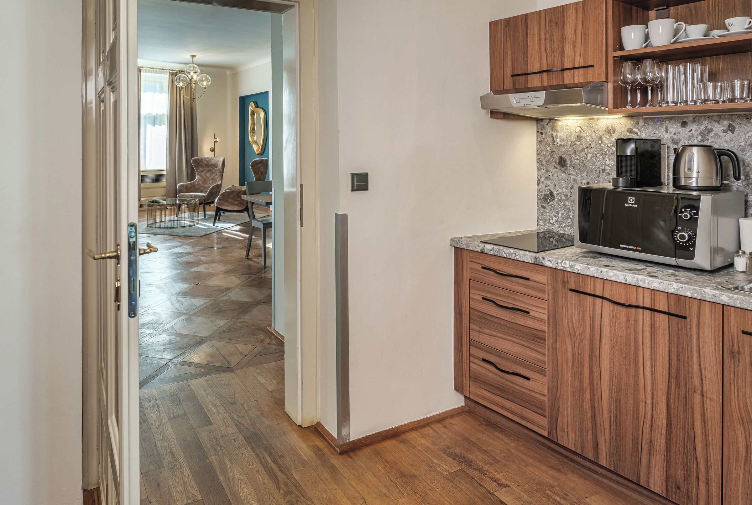 Una cocina moderna con armarios de madera, microondas integrado y cafetera.