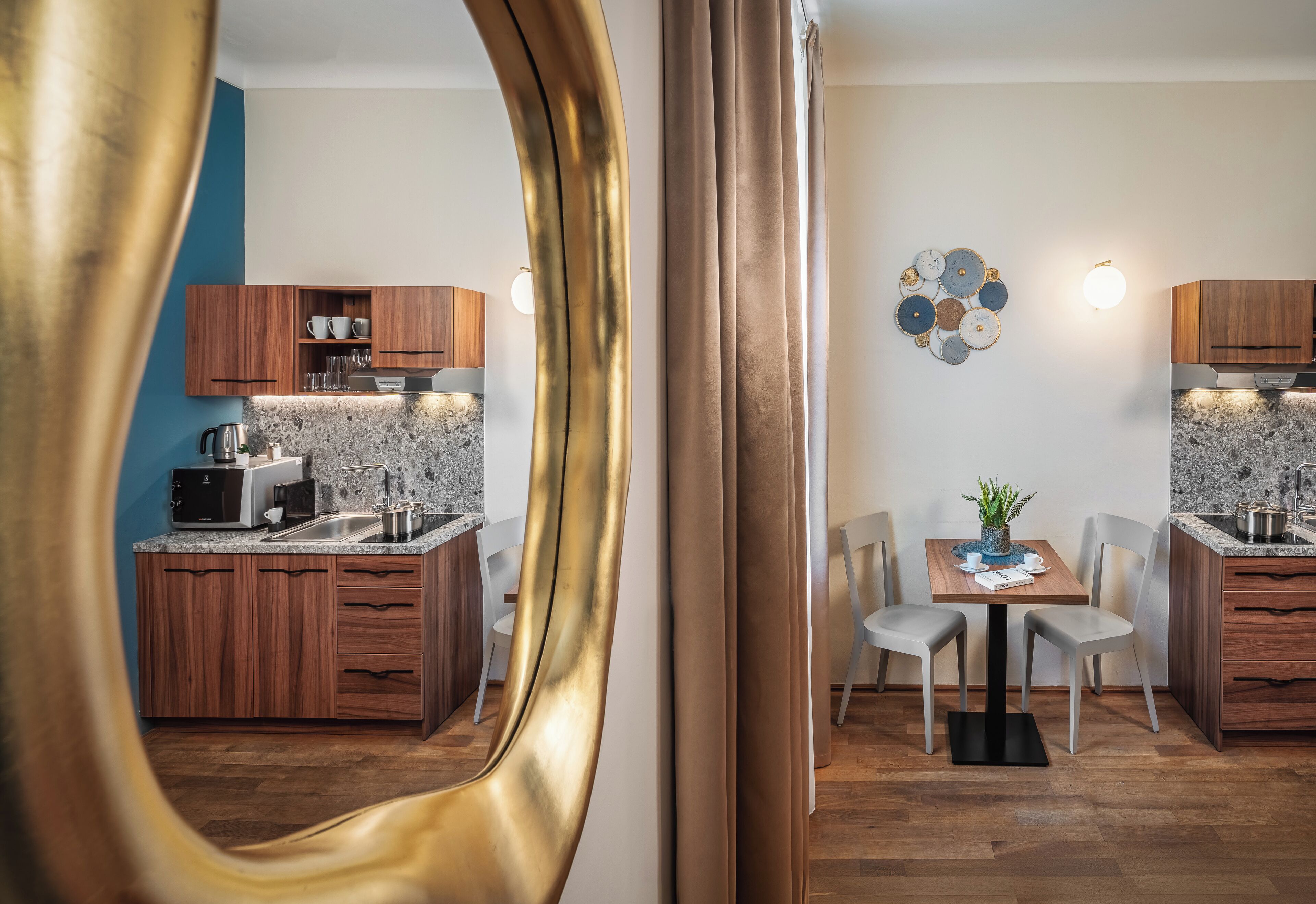 Een moderne keuken met houten kastjes, granieten aanrechtbladen en een eethoek met een tafel en stoelen.