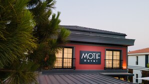 Un hôtel à la façade rouge, sur lequel on peut lire l’inscription « MOTIE Hotel ».