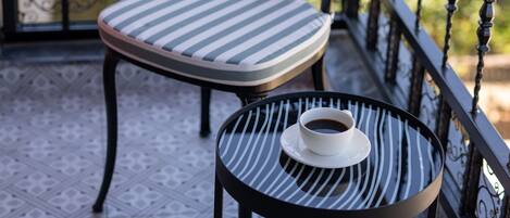A balcony with a chair and a small table, both with striped cushions.